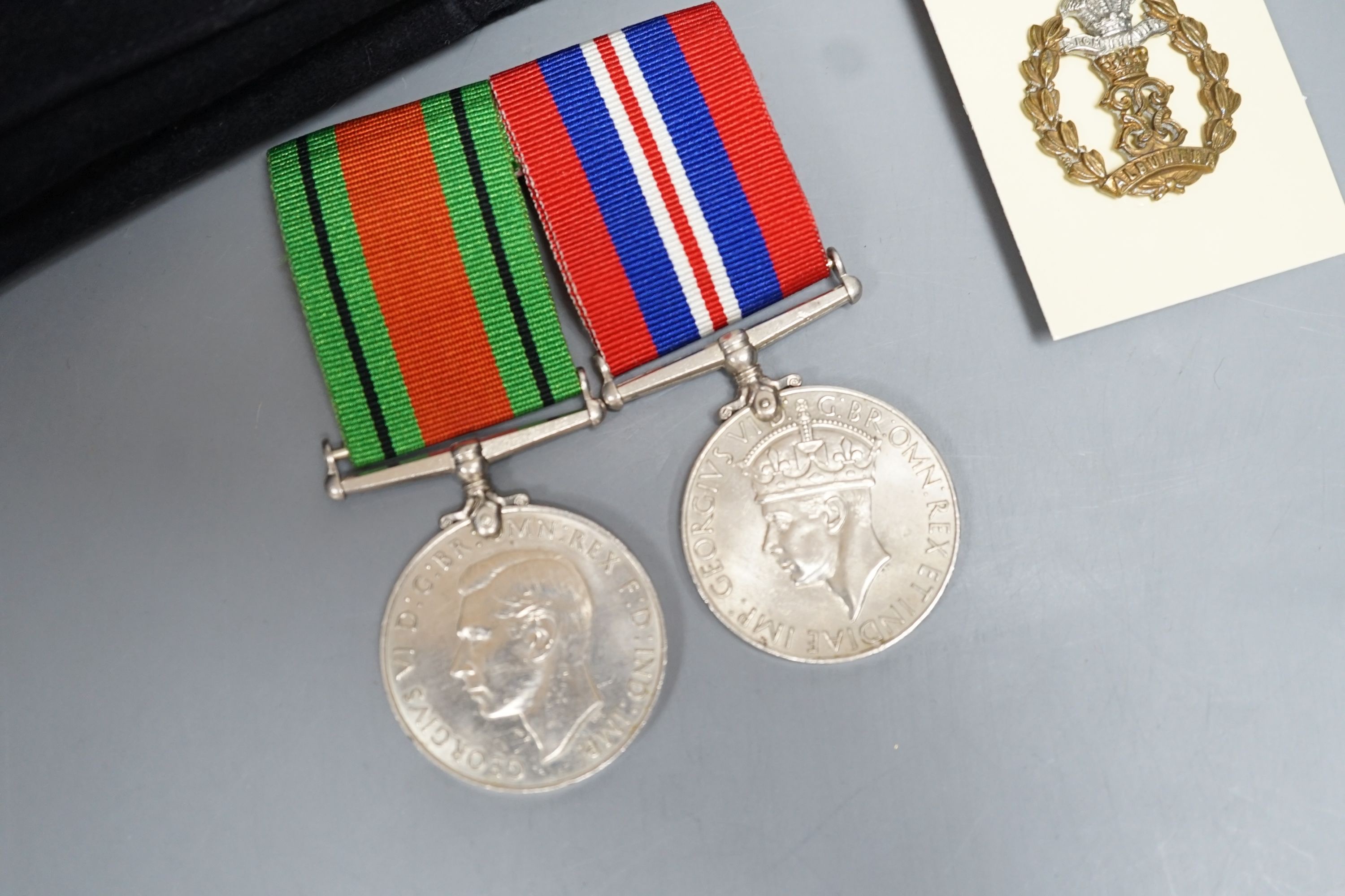 A WWII pair of medals, Middlesex Regiment cap and badge and WWI swagger stick.